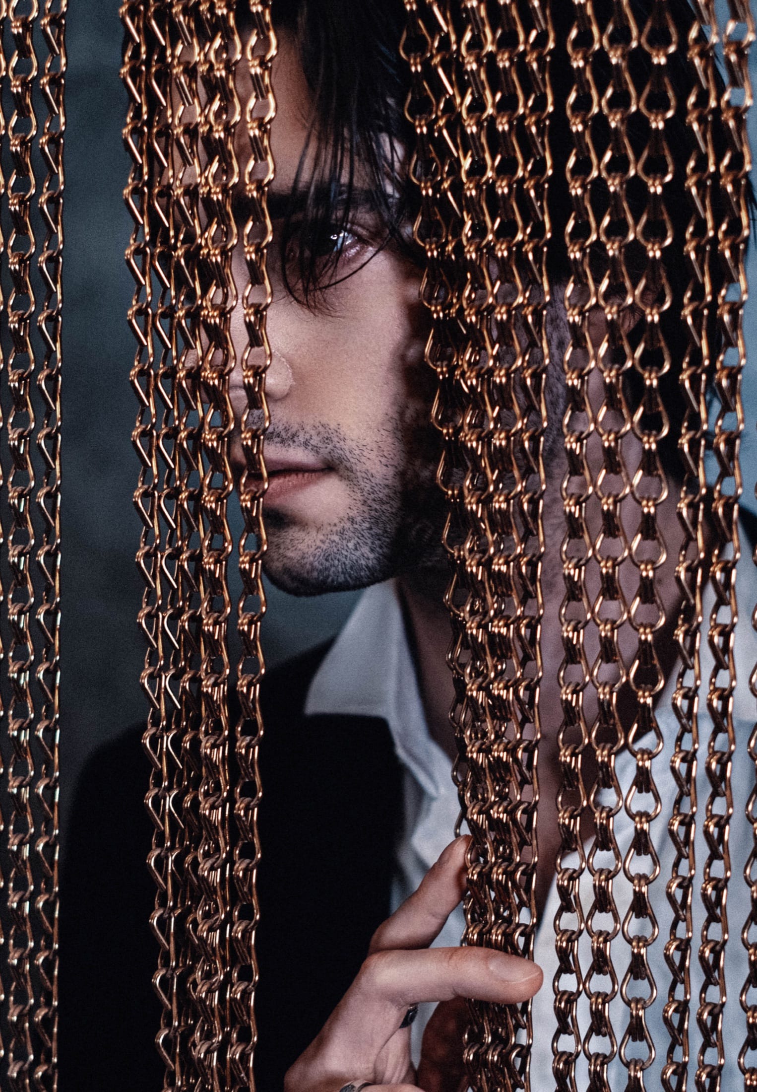 Portrait behind a bead curtain, warm light
